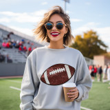Sequins Football Patch Chenille Patch, a close-up of a fashion-forward woman at a sports stadium wearing a sweatshirt featuring a sequin football patch, with sunglasses and bright red lipstick.