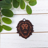 Lion Mascot Leather Keychain, brown and black lion head design on a white wooden background with green leaves