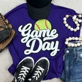 Softball White Game Day Chenille Patch, a white patch with a yellow-green softball and red stitches on a purple shirt with sporty accessories.