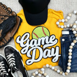 Softball White Game Day Chenille Patch, embroidered patch with a green softball and white 'Game Day' text on a yellow t-shirt surrounded by sneakers, a black cap, and wooden bead necklaces.