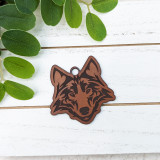 Wolf Mascot Leather Keychain, detailed brown and black leather keychain in wolf mascot design on a white wooden surface with green leaves
