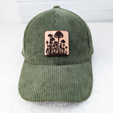 Mushroom Leather Hat Patch, forest green corduroy baseball cap with mushroom graphic patch on front.