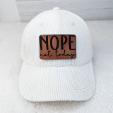 Nope Not Today Leather Hat Patch, white corduroy cap with a brown leather patch embroidered with the phrase "NOPE not today" in black lettering.