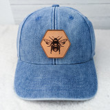 Bee Leather Hat Patch, a leather hexagon-shaped patch featuring a detailed illustration of a bee, mounted on a blue denim cap.
