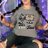 Let's Summon The Dead DTF Heat Transfer, graphic design of cartoon characters on a T-shirt featuring a smiling Ouija board and a demon skull with the text 'Let's Summon The Dead'.