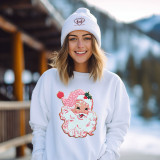 Pink Santa Chenille Patch, pink Santa Claus embroidery detail on a white sweater worn by a smiling woman outdoors near snowy mountains.