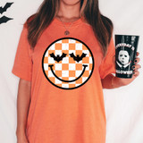Checkered Halloween Happy Face DTF Heat Transfer, orange and white checkered pattern with black bat wings and a smiling face.