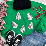 Mini Snack Cake Sequin Patch, small Christmas tree-shaped sequin patches with red and white stripes, on a green sweatshirt surrounded by holiday-themed clothing and accessories.