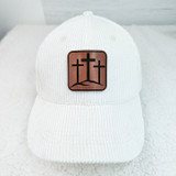 Triple Cross Leather Hat Patch, white baseball cap with brown leather patch featuring three crosses design.