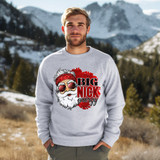 Big Nick Energy DTF Heat Transfer, a creative and vibrant graphic design featuring Santa Claus with sunglasses and a red bandana, placed on a light gray sweatshirt worn by a man outdoors with snow-capped mountains in the background.