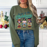 Crushin' It This Christmas DTF Heat Transfer, Christmas-themed graphic on a green sweatshirt with nutcracker characters.