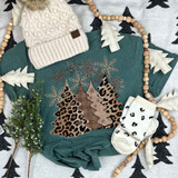 Leopard Christmas Trees DTF Heat Transfer, Christmas-themed teal sweatshirt with leopard print and plaid design, surrounded by holiday decorations and white mittens.