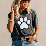 Dog Paw White Chenille Patch, white embroidered paw print patch with black border on a woman's T-shirt.