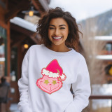 PINK Grouchy Guy Chenille Patch, cheerful young woman wearing a white sweatshirt with colorful patch of a pink grumpy face with a Santa hat, outdoors in winter.