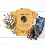 Full Moon Feelin Cute May Make Everyone Crazy Later, IDK Sublimation Transfer T-Shirt, yellow graphic tee with moon design and humorous text, displayed with denim shorts, brown shoes, and cotton bouquet on white wooden background.