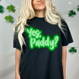 Yes Paddy, DTF Heat Transfer product applied on a black T-shirt worn by a woman with blonde hair, with festive light and shamrock decorations in the background.