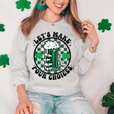 Let's Make Pour Choices DTF Heat Transfer, woman wearing a festive gray sweatshirt with a green beer mug and shamrocks design, surrounded by green glitter shamrocks.