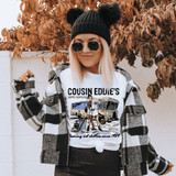 Cousin Eddie's Septic Services Sublimation Transfer, humorous graphic t-shirt featuring a cartoon man with a septic truck and cleaning tools, casual woman wearing the shirt outdoors.