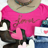 LOVER Red Sequin Patch, close-up of a pink T-shirt with the word 'Lover' in red sequins, paired with denim shorts, cowboy boots, and decorative hearts for a fashionable look.