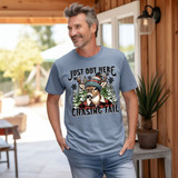 Just Out Here Chasing Tail DTF Heat Transfer, image of a man wearing a humorous t-shirt with a deer illustration and festive winter graphics