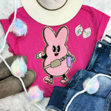 Trendy Pink Bunny Chenille Patch, pink bunny wearing goggles and holding a water bottle, on a pink t-shirt with floral earrings and colorful fluffy pom-pom accessories.
