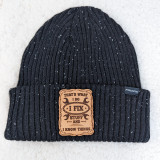 That's What I Do Leather Hat Patch, black knit beanie hat with a leather patch that says 'That's What I Do, I Fix Stuff and I Know Things'.