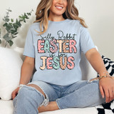 Silly Rabbit Easter Is For Jesus DTF Heat Transfer, woman wearing a light blue T-shirt with colorful Easter-themed text design.