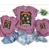 Vintage Sanderson Sisters Screen Print Heat Transfer, festive Halloween-themed graphic printed on purple T-shirts, featuring the Sanderson Sisters from Hocus Pocus with detailed illustrations and colorful design.