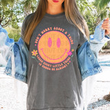 Don't Worry About A Thing DTF Heat Transfer, colorful smiley face design with flowers, and motivational quote on a woman's t-shirt.