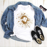Baseball glitter splatter sublimation transfer, gold glitter splatter design with baseball image printed on white t-shirt, denim shirt, shoes, and sunglasses placed around, on light wooden background.