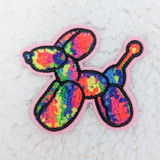 NEON BALLOON DOG Chenille HAT/POCKET Patch, colorful embroidered patch of a balloon dog with multicolor chenille yarn, pink fabric border, on a marble surface.