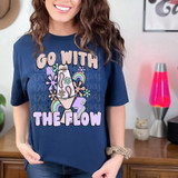 Go With The Flow DTF Heat Transfer, colorful cartoon design of a champagne bottle overflowing with flowers, rainbows, and lightning bolts on a navy blue t-shirt.