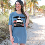 Spooky Beach Essentials DTF Heat Transfer, a stylish illustration of a panda with sunglasses, tropical drink, and Halloween elements on a t-shirt worn by a woman at the beach.