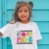 Peace Out Pre-K DTF Heat Transfer, girl wearing a white T-shirt with colorful printed design featuring a peace sign, smiley face, and the words 'OUT PRE-K' in vibrant letters.