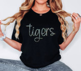 Tigers Sequin Patch, close-up of a woman wearing a black T-shirts with the word 'tigers' in colorful sequins, accessorized with rings, necklace, and bracelet.