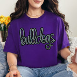 Bulldogs Sequin Patch, a sparkly embroidered applique patch featuring the word Bulldogs in colorful sequins on a purple t-shirt worn by a woman.