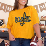 Eagles Sequin Patch, close-up of a yellow T-shirt with a sparkling sequin eagle patch on the front.