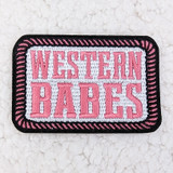 Western Babes Embroidered HAT/POCKET Patch, pink and white embroidered patch with black border featuring the text 'Western Babes'.