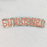 Sunkissed Embroidered Glitter Hat/Pocket Patch, pink embroidered text on a silver glitter background.