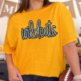 Wildcats Sequin Patch, a yellow T-shirt with the word 'wildcats' in sequined script on the front.