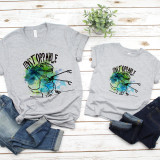 T rex short arms Unstoppable Sublimation Transfer, grey t-shirts with a colorful dinosaur graphic and the word 'Unstoppable' on a wooden surface with denim jeans and a plant