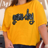Game Day Sequin Patch, a black and silver sparkling embroidered patch with the text 'game day' on a yellow T-shirt.