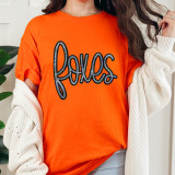 Foxes Sequin Patch, close-up view of an orange t-shirt with a black and colorful sequined foxes patch design on the front.