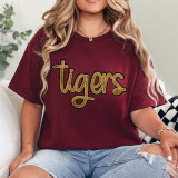 Tigers Gold Sequin Patch, a close-up view of a maroon t-shirt with a gold sequined tiger's name embroidered on the front.