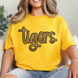 Tigers Gold Sequin Patch, close-up of a woman wearing a yellow T-shirt with a glittery tiger logo patch.