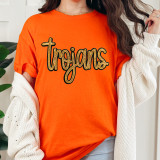Trojans Gold Sequin Patch, close-up of a garment featuring a gold sequin patch spelling 'Trojans' on an orange T-shirt.