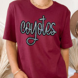Coyotes Sequin Patch, glittery sequin patch spelling 'Coyotes' on a maroon t-shirt.