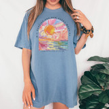 His Mercies Are New Every Morning DTF Heat Transfer, colorful painted sunrise design on a blue T-shirt worn by a woman.