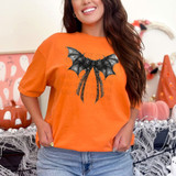 Gothic Coquette Bow DTF Heat Transfer, black bat wings with a bow and lace design on an orange t-shirt.
