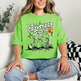 It Was A Graveyard Smash DTF Heat Transfer, woman wearing a bright green t-shirt with a skeleton graveyard Halloween design.